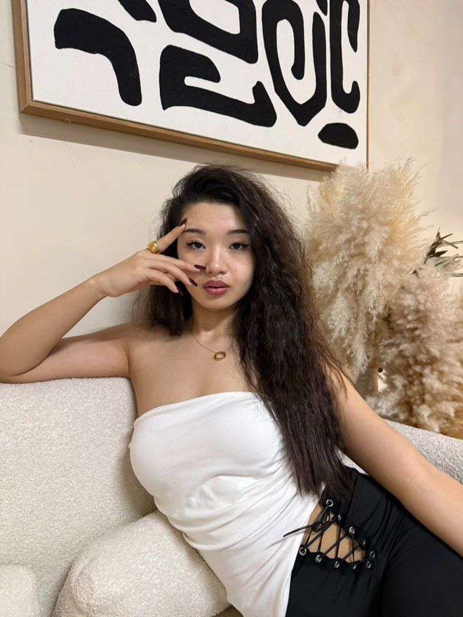 Content creator posing on a cream couch